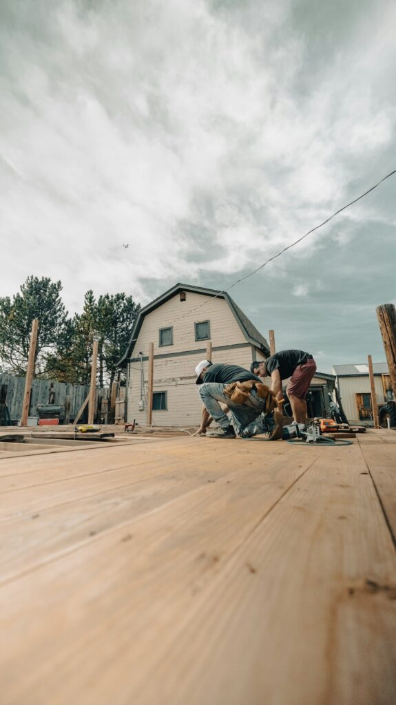 Real photograph of workers framing a wooden deck outside a residence
