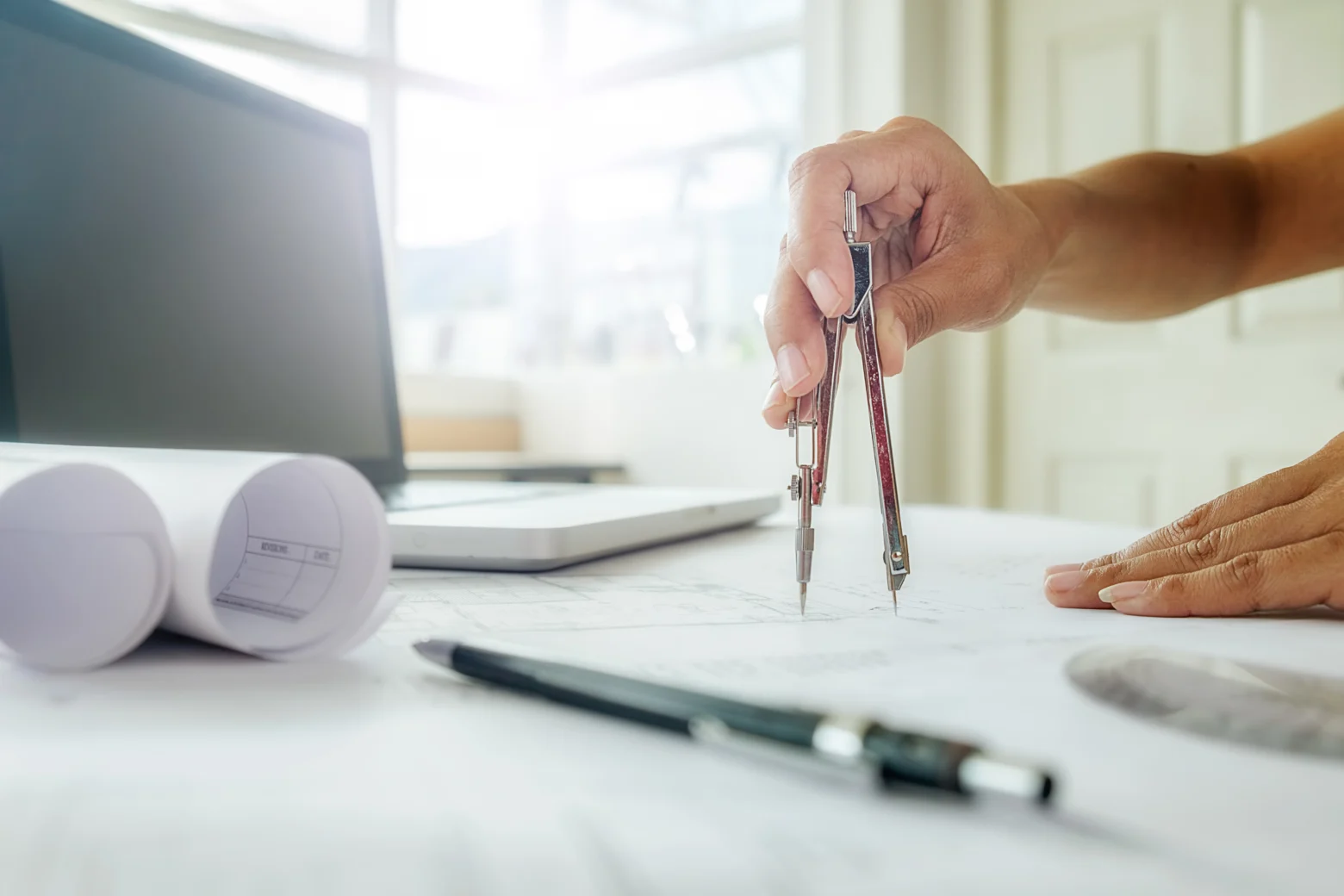 Architectural drawing being reviewed and marked with a pencil, illustrative stock photo